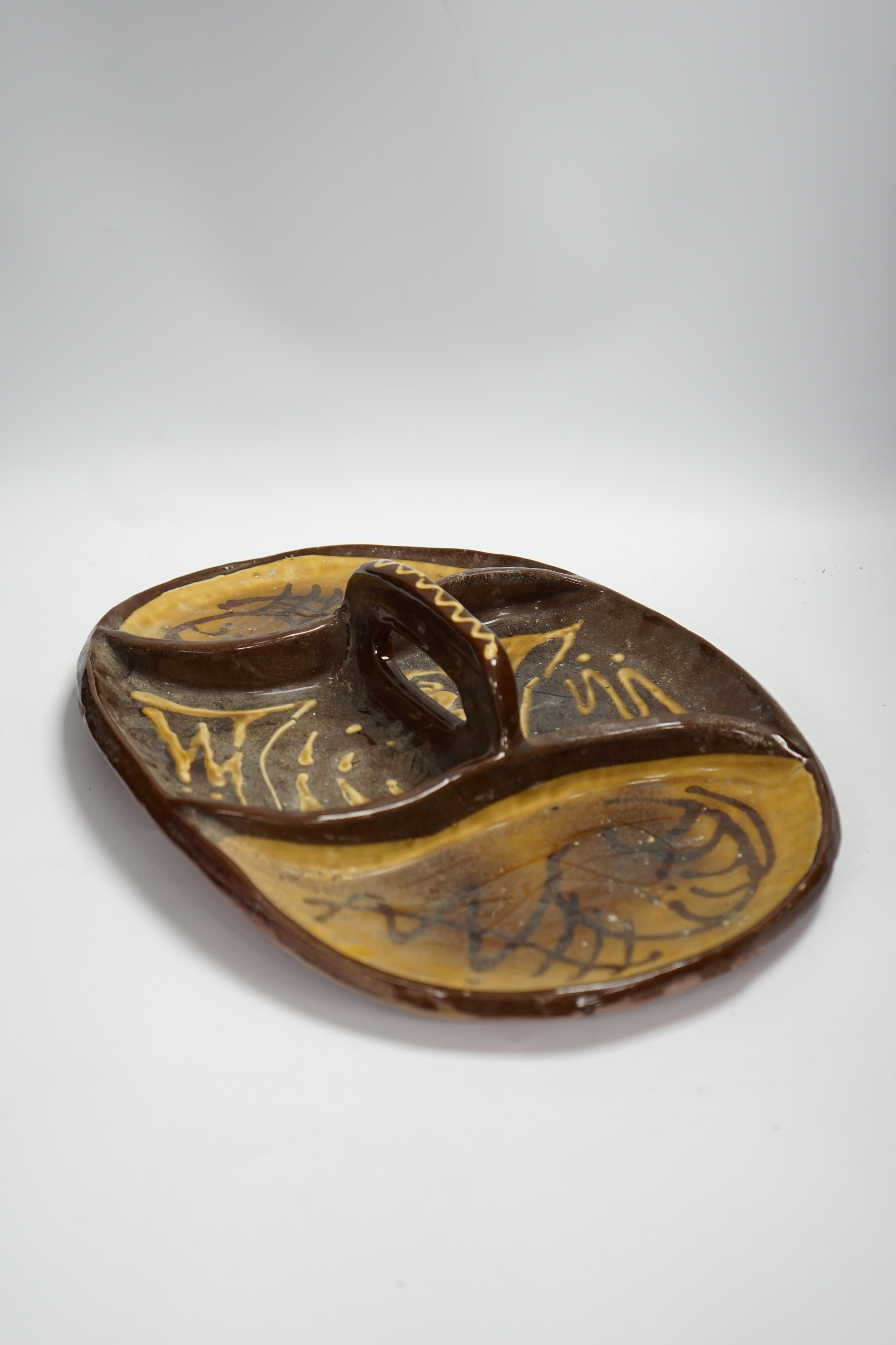 A set of nine studio pottery plates together with a slipware dish, 46cm long